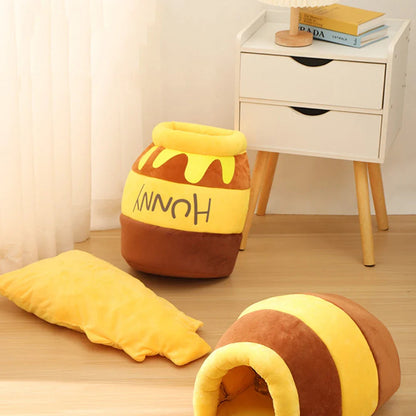 Honey pot–style cat bed shown upright with soft yellow cushion beside it.