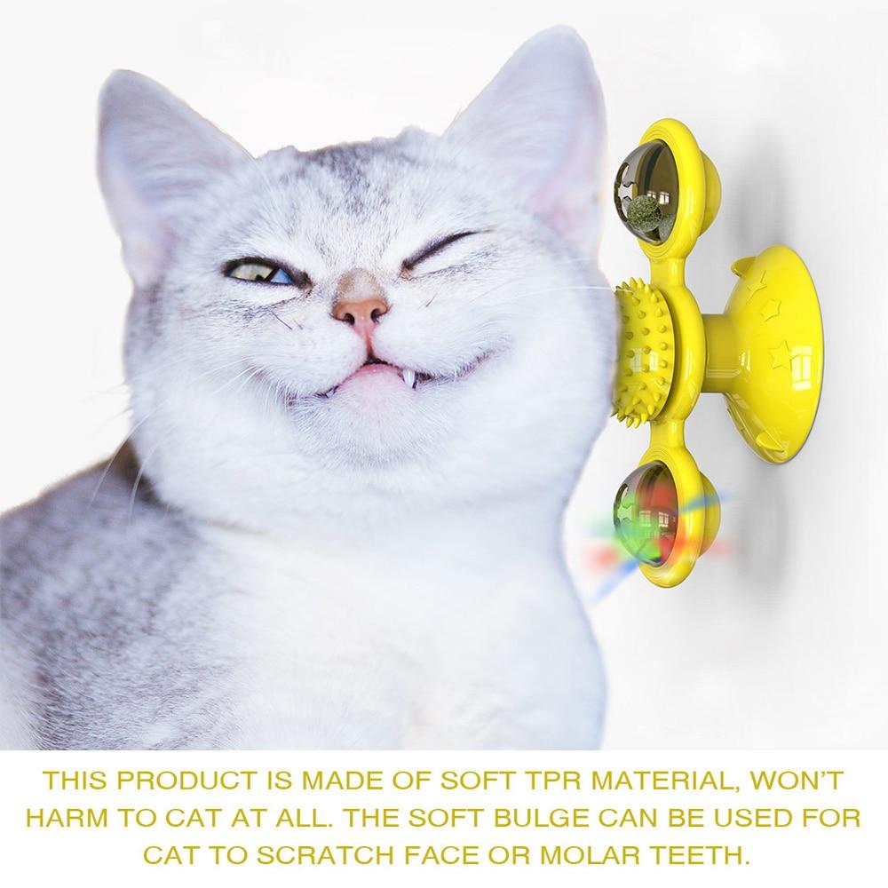 Cat rubbing face on yellow spinning suction-cup toy with two LED balls and textured massage center