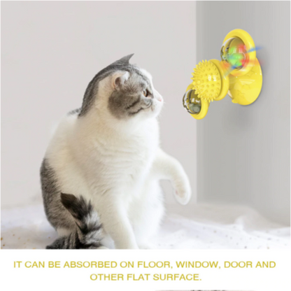 Cat watching yellow spinning toy attached to wall via strong suction cup